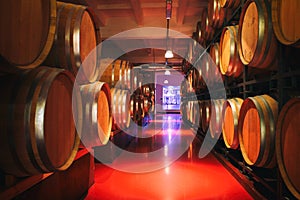 Oak barrels with wine in dark cellar. Modern production of wine with the observance of age-old traditions. photo