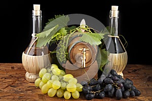 In oak casks with vines and grapes white and black photo