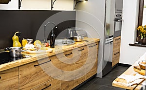Oak kitchen worktop on kitchen with a sink, cookstove and food ingredients, bottle and kitchen facilities. Practical