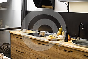 Oak kitchen worktop on kitchen with a sink, cookstove and food ingredients, bottle and kitchen facilities. Practical