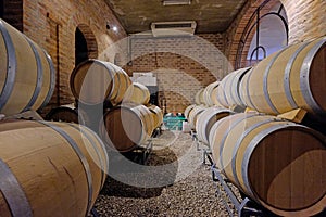 Oak wine barrels in the cellar of a Malbec winery factory in San Juan, Argentina, South America, also seen in Mendoza