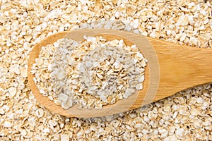 Oat cereal flake. Grains in wooden spoon. Close up.