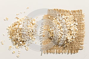 Oat cereal grain. Close up of grains spreaded over white table.