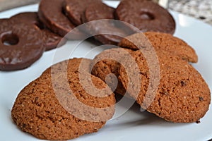 Oat cookies and chocolate bisquit on a white plate photo