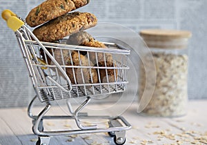 oat cookies in shopping cart, oat on the wooden background