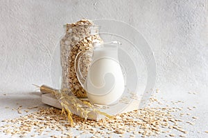Oat flakes, out milk on a table. Plant-based healthy and vegetarian eating and drink. Selective focus, close up