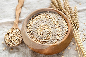Oat flakes, rolled oats in wooden bowl