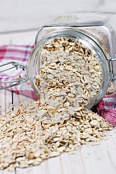 Oat flakes spilling from the glass jar.