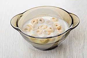 Oat flakes with yogurt in brown bowl on wooden table