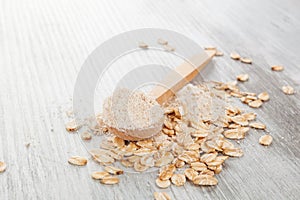 Oat flour in wooden spoon.