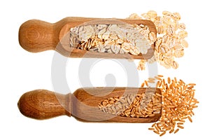 Oat grains and oat flakes in wooden scoop isolated on white background. Top view. Flat lay