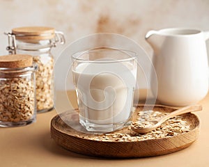 Oat milk in a glass, flakes of baked cereals. Milk substitute, milk for vegetarians. Flatlay. Copy space.