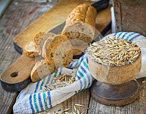 Oat and oatmeal bread on old wooden background