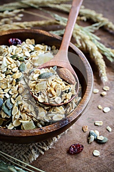 Oat and whole wheat grains flake in wooden bowl