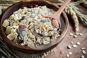 Oat and whole wheat grains flake in wooden bowl