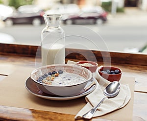 oatmeal with berries and glass of milk on table. Healthy breakfast concept