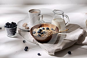 Oatmeal with blueberries, milk and cup of coffee