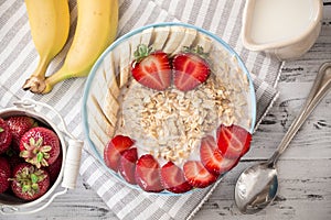 Oatmeal in bowl with strawberries and bananas