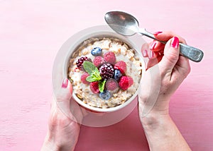 Oatmeal cereal with milk and berries top view.