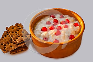 An oatmeal in the clay brown bowl with red currant berries for breakfast is on a white background photo