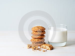 Oatmeal cookies with flax seeds and milk in a glass, healthy snack. Light background, grey light wall