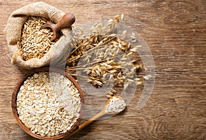 Oatmeal flakes, grains and ears of oats on wooden table