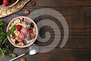 Oatmeal with freeze dried fruits, nuts and mint on wooden table, flat lay. Space for text