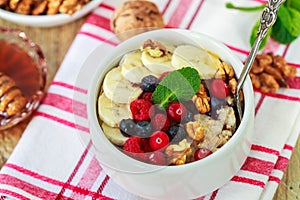 Oatmeal with fresh berries, bananas nuts and honey. Healthy Breakfast