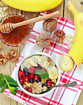 Oatmeal with fresh berries, bananas nuts and honey. Healthy Breakfast