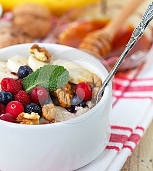 Oatmeal with fresh berries, bananas nuts and honey. Healthy Breakfast