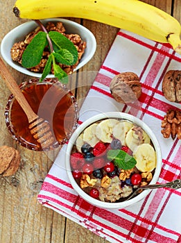 Oatmeal with fresh berries, bananas nuts and honey. Healthy Breakfast