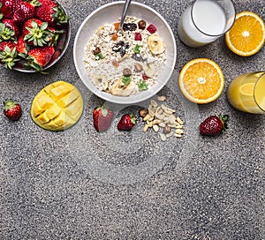 Oatmeal with fruit and freshly squeezed orange juice border ,place for text wooden rustic background top view close up