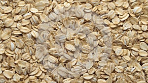 Oatmeal. Oat flakes. Close-up rotating. Dry oat flakes grains background, close up rotation loopable 4k top view. Food