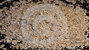 Oatmeal. Oat flakes. Close-up rotating. Dry oat flakes grains background, close up rotation loopable top view.