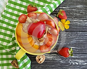 Oatmeal porridge, apricot, strawberry, nutrition breakfast heart on a wooden background