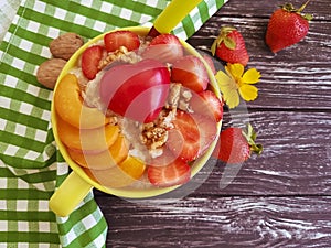 Oatmeal porridge, apricot, strawberry, breakfast heart on a wooden background