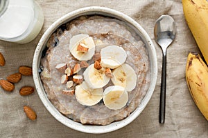 Oatmeal porridge with banana and nuts, top view