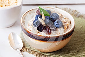 Oatmeal porridge with berries still life, blueberries, raisins, birch, cut down