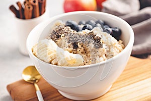 Oatmeal porridge with blueberries, banana and chia seeds in bowl