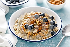 Oatmeal porridge with blueberry, almonds, walnuts, flax seeds, sesame and chia. Healthy vegetarian food for breakfast