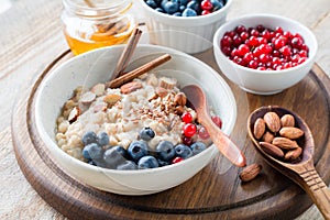 Oatmeal porridge bowl with fruits, nuts and cinnamon in bowl