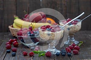 Oatmeal porridge in bowl topped with fresh blueberries, raspberries and cherries