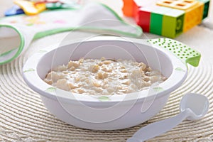 Oatmeal porridge for children nutrition on white tablecloth