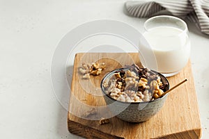 Oatmeal porridge with nuts, chocolate in a gray bowl, a glass of milk. Breakfast, healthy food.Copy space. Good morning