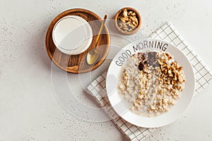 Oatmeal porridge on a plate that says good morning and a cup of milk. Healthy food. Breakfast. Copy space