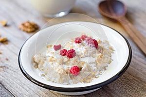 Oatmeal porridge with raspberry and milk, healthy breakfast