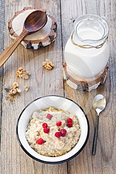 Oatmeal porridge with raspberry and milk, healthy breakfast