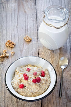 Oatmeal porridge with raspberry and milk, healthy breakfast