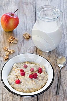Oatmeal porridge with raspberry and milk, healthy breakfast