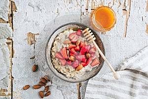 Oatmeal porridge with strawberries, almond nuts and honey